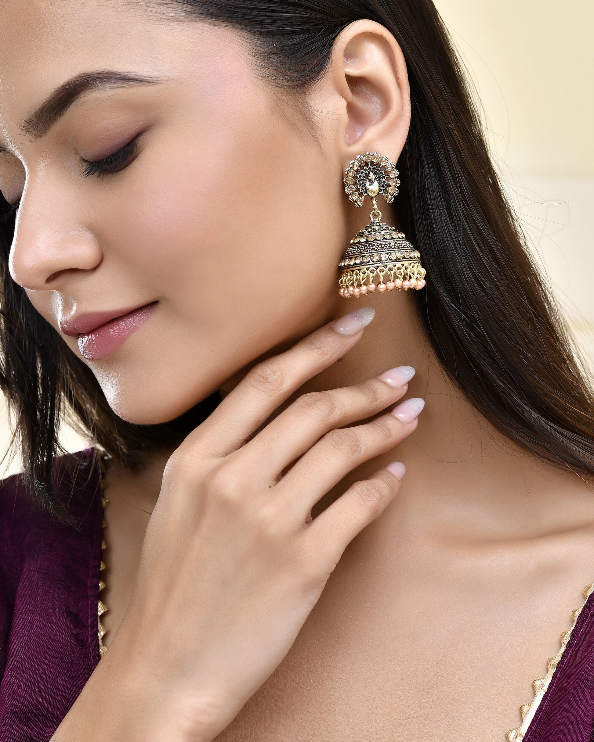 Jewels Nest Antique Gold-Polished Jhumka Earrings with Floral Detailing and Stone Embellishments Jewels Nest