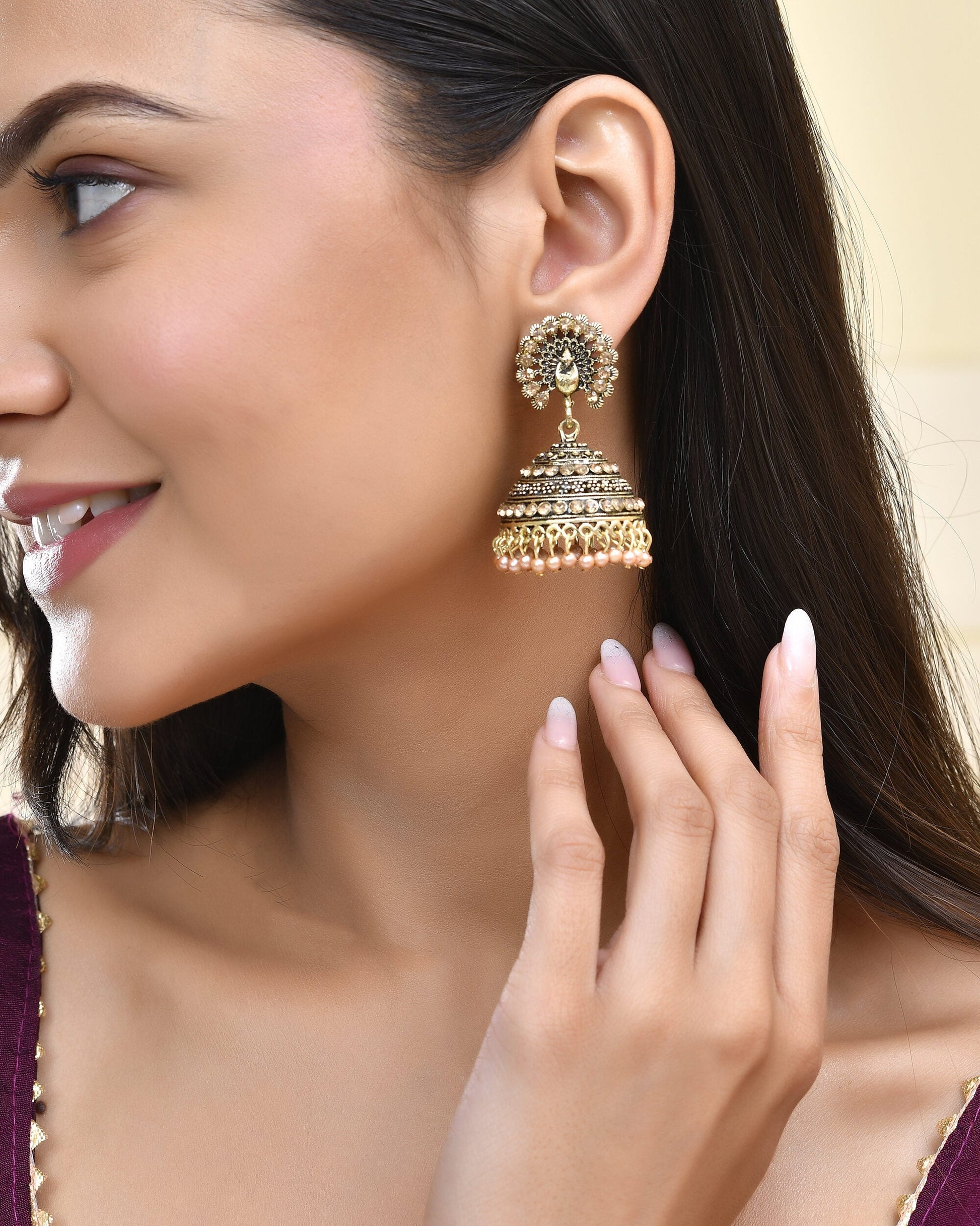 Jewels Nest Antique Gold-Polished Jhumka Earrings with Floral Detailing and Stone Embellishments Jewels Nest